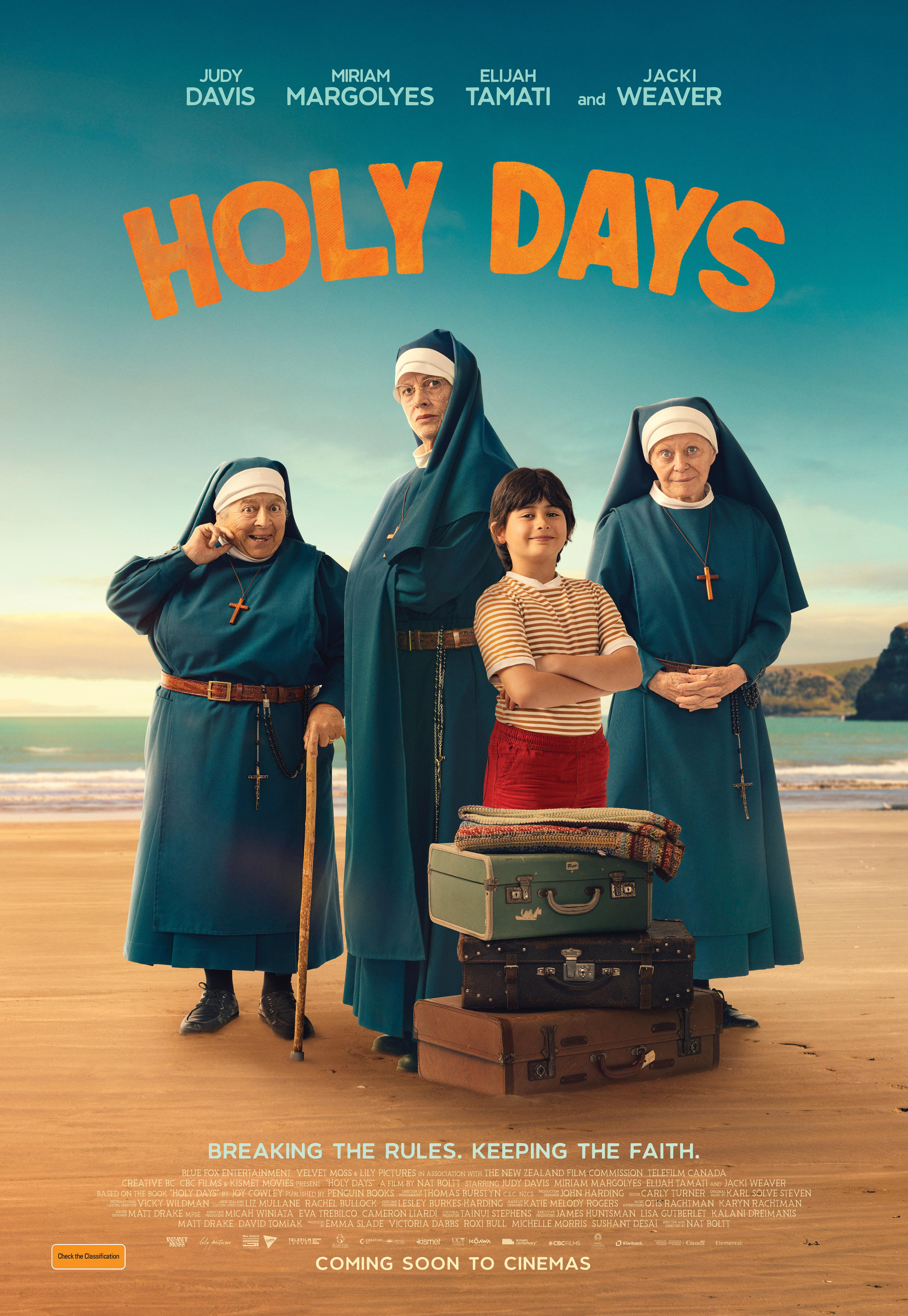 three nuns and a young boy pose on a beach in front of suitcases