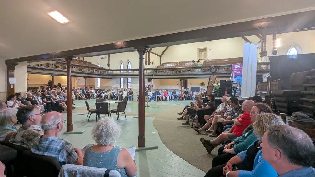 People sitting around a large room during the facilitated discussion