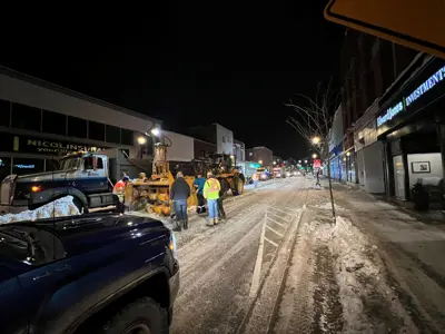 People loading snowbanks into dumptruck