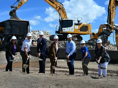 People in hard hats lifting dirt