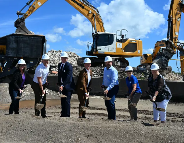 People in hard hats lifting dirt