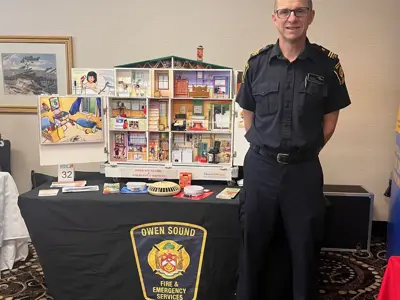 man standing with model fire hazards house