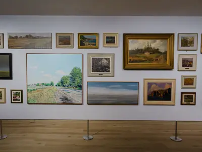 Salon-style display of landscape paintings in the Forecast exhibition.