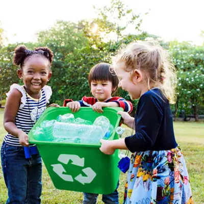 Three kids holding one recycle bin together