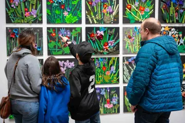 People look at Upcycle TOM art works on display