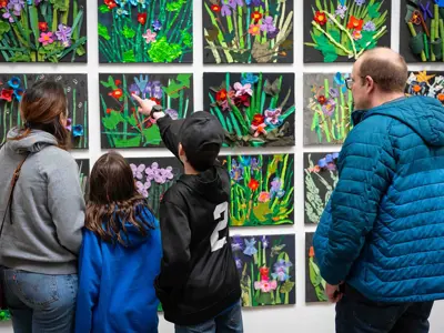 People look at Upcycle TOM art works on display