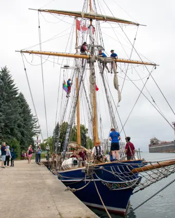 Tall sailing ship docked in Owen Sound with people on it